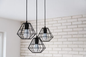 A modern loft chandelier made of black wire in a stylish white interior.