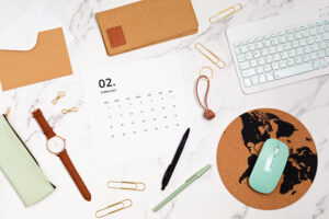 Desktop with calendar for february and office supplies. home office, social media blog, schedule, planning concept. Flatlay, top view